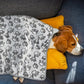 tan and white dog laying asleep under the grey fluffy blanket